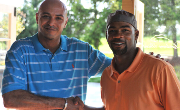 two men wearing casual clothing shaking hands