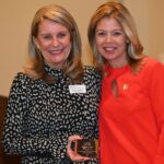 Dulles Area Association of Realtors President Phyllis Stakem handing a plaque to Melissa Fones