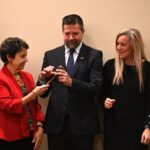 Dulles Area Association realtors passing down an award gavel to team members