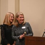 dulles area association of realtors presenting an award and holding a conversation for phyllis stakem at the holiday party