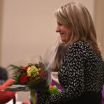 dulles area association of realtors handing flowers at the holiday party
