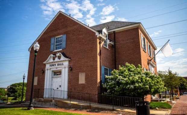 Under a serene blue sky, capture a side view of Herndon, Virginia's City Hall, epitomizing the town's charm and civic pride.