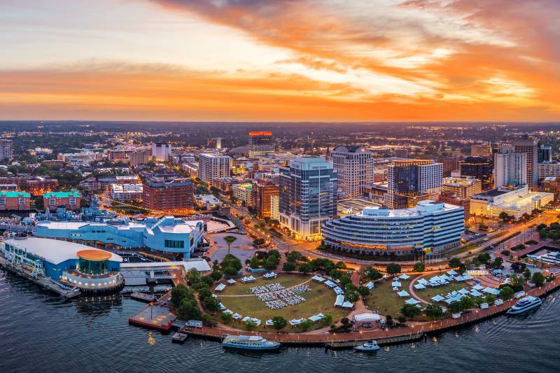 Norfolk, Virginia, USA downtown city skyline from over the Elizabeth River at dusk.