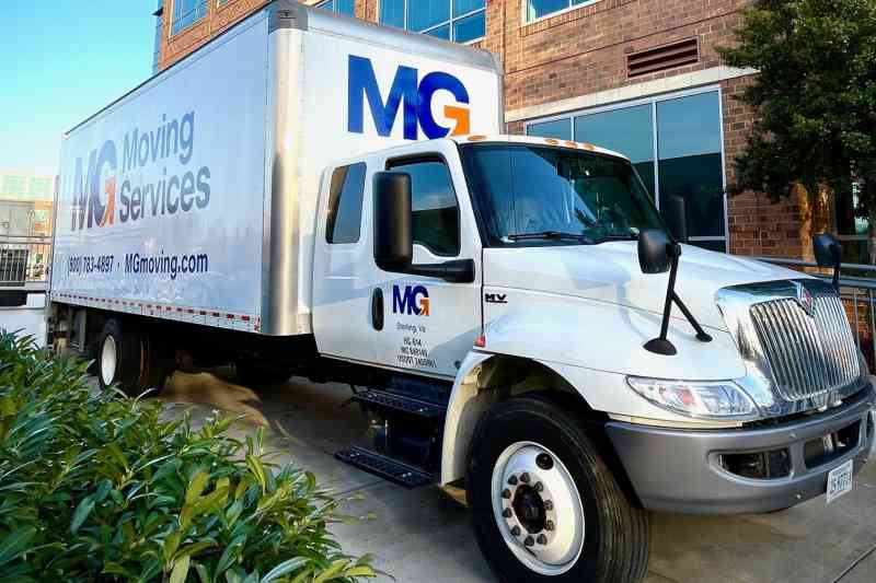 mg moving truck in front of an office building