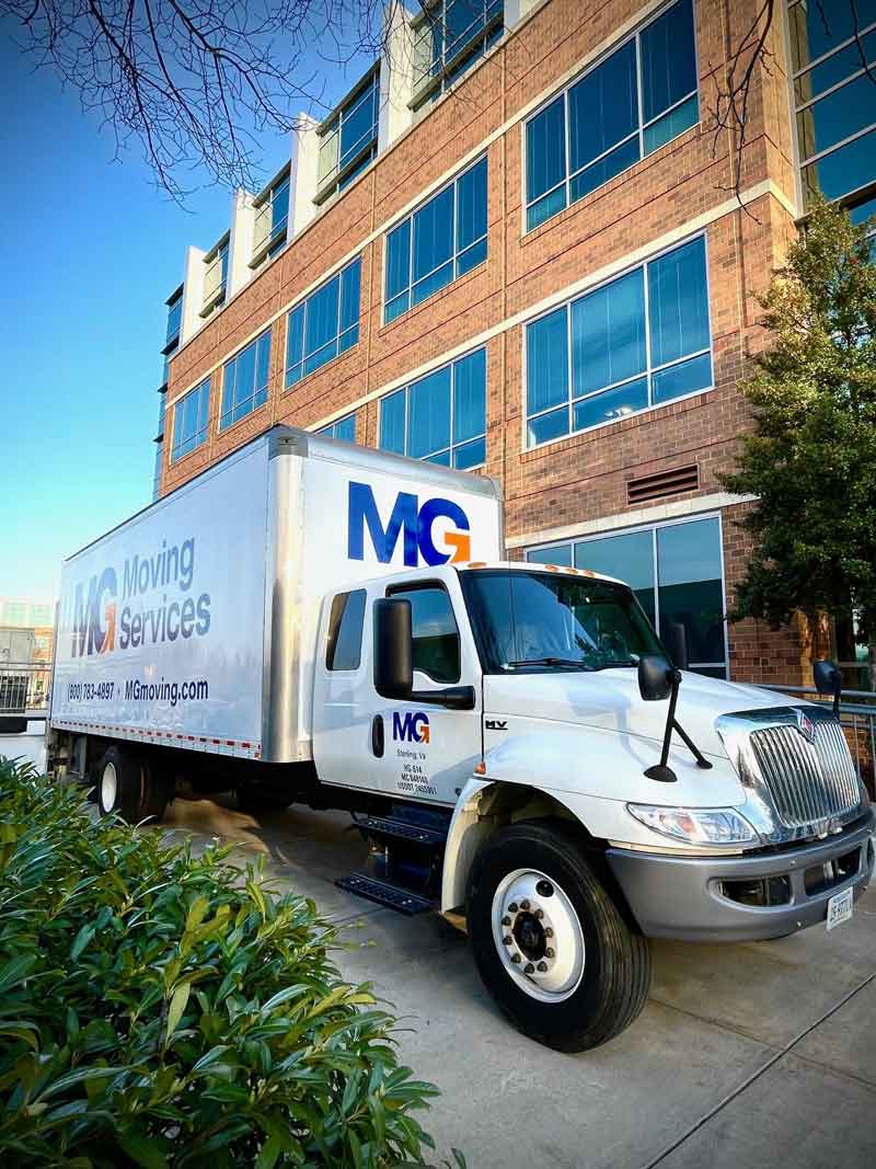 MG Moving truck outside of a commercial office building