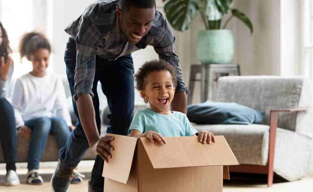 dad and son playing with moving boxes during a moving day