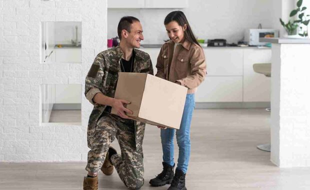 military family holding a box during moving day