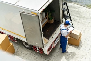 top view of workers unloading boxes from van outdoors