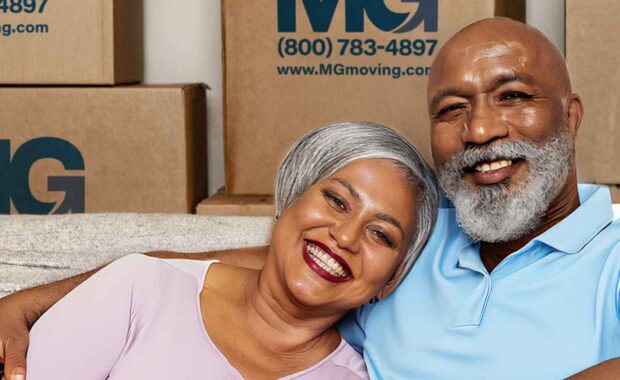 senior couple smiling in front of moving moxes