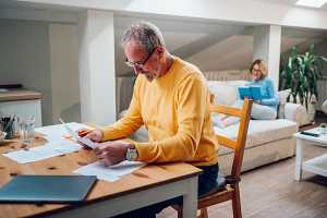 senior man reviewing moving paperwork at a desk