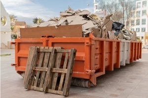 huge heap on metal Big Overloaded dumpster waste container filled with construction waste