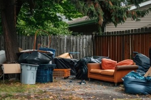 urban backyard cluttered with furniture and trash bags