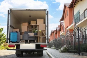 van full of moving boxes and furniture near house