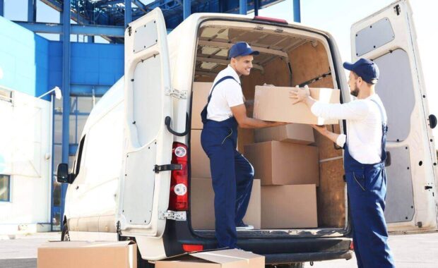 delivery men unloading moving boxes from car
