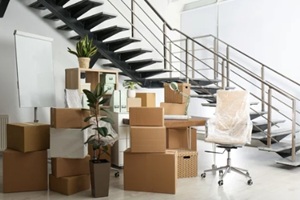 cardboard boxes and furniture near stairs in office