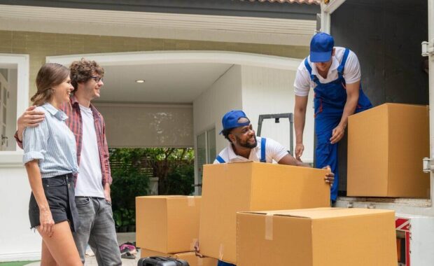 man movers worker in blue uniform unloading cardboard boxes from truck.Professional delivery and moving service